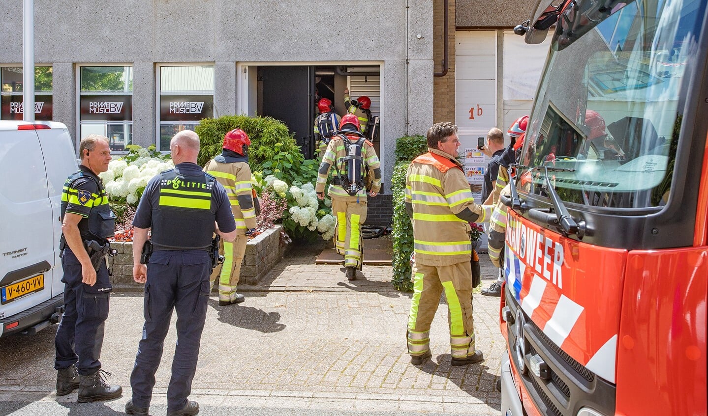 De brandweer sloopt een stuk muur om zeker te weten dat de brand uit is.