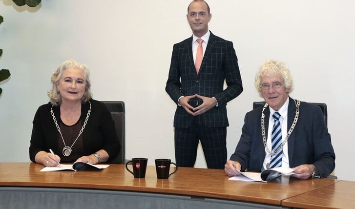 Burgemeester Joan de Zwart-Blocht van Blaricum en loco-burgemeester Peter Calis van Laren ondertekenen de overeenkomst.