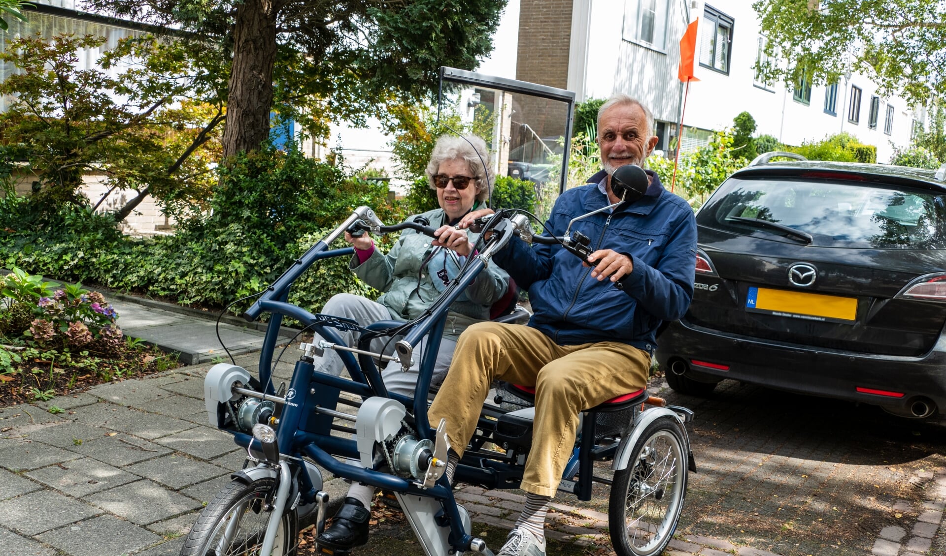 De nieuwe duofiets van de Zonnebloem Muiden & Muiderberg heeft een coronaproof scherm tussen de fietsstoeltjes, zodat er zonder mondkapje gefietst kan worden. 