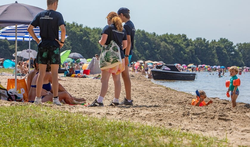 <p>De Junior Strandwachten in gesprek met ouders op het strand.</p>