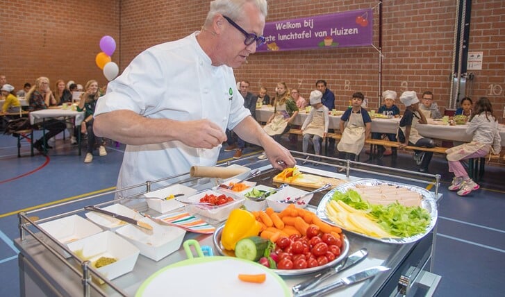 Tv-kok Rudolph van Veen hielp de leerlingen met het maken van een gezonde broodrol.