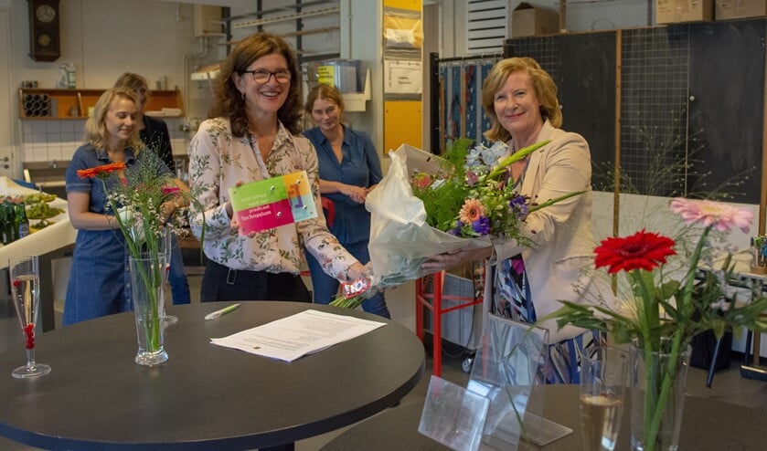 Wethouder Marlous Verbeek (r) feliciteert rector Tanja de Ruijter met het certificaat.