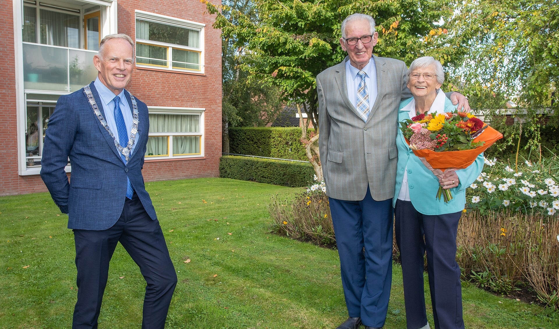 Burgemeester Ter Heegde bracht echtpaar De Gooijer-Slok zijn felicitaties en een bos bloemen.
