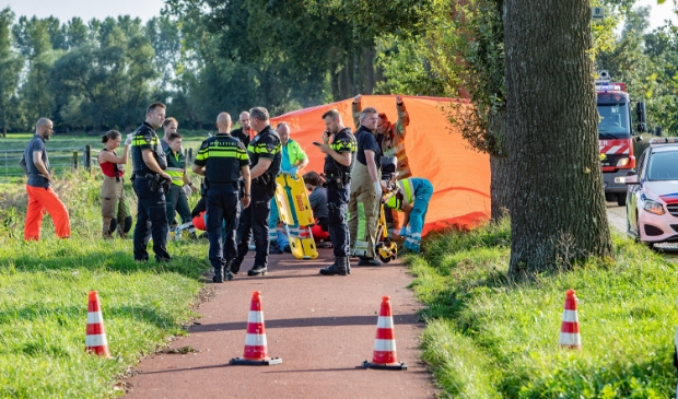 <p>De brandweer bekommert zich met ambulancepersoneel om de fietser.</p>