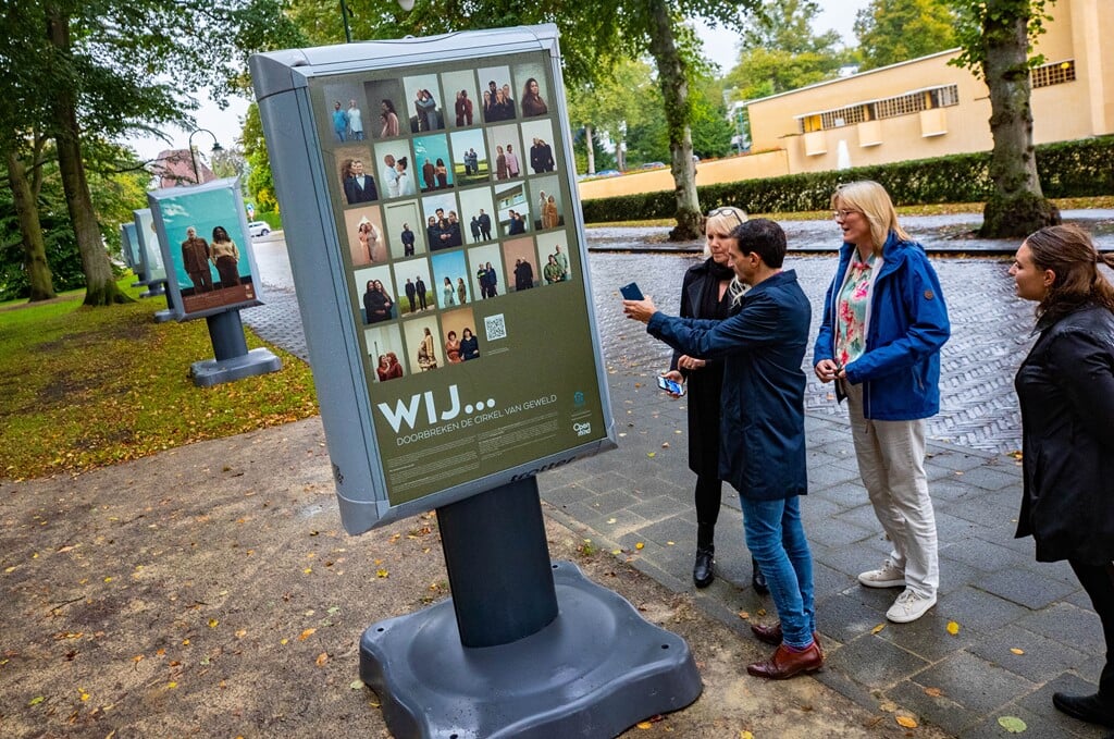 Maarten Hoelscher (met telefoon in de hand) en zijn Hilversumse collega Karin Walters (blauwe jas) openden dinsdag de tentoonstelling 'Wij...doorbreken de cirkel van geweld' in het Dudokpark.