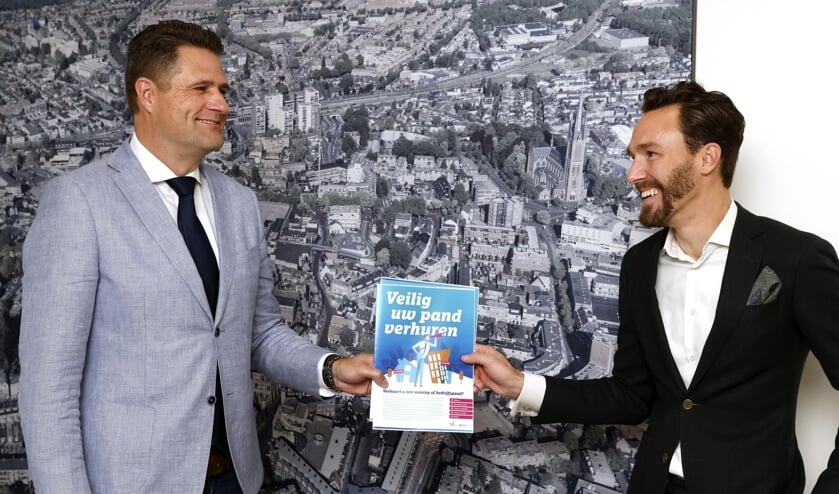 <p>Wethouder Arno Scheepers (rechts) overhandigt brochure ‘Veilig uw pand verhuren’ aan Jeroen Jones (links). </p>