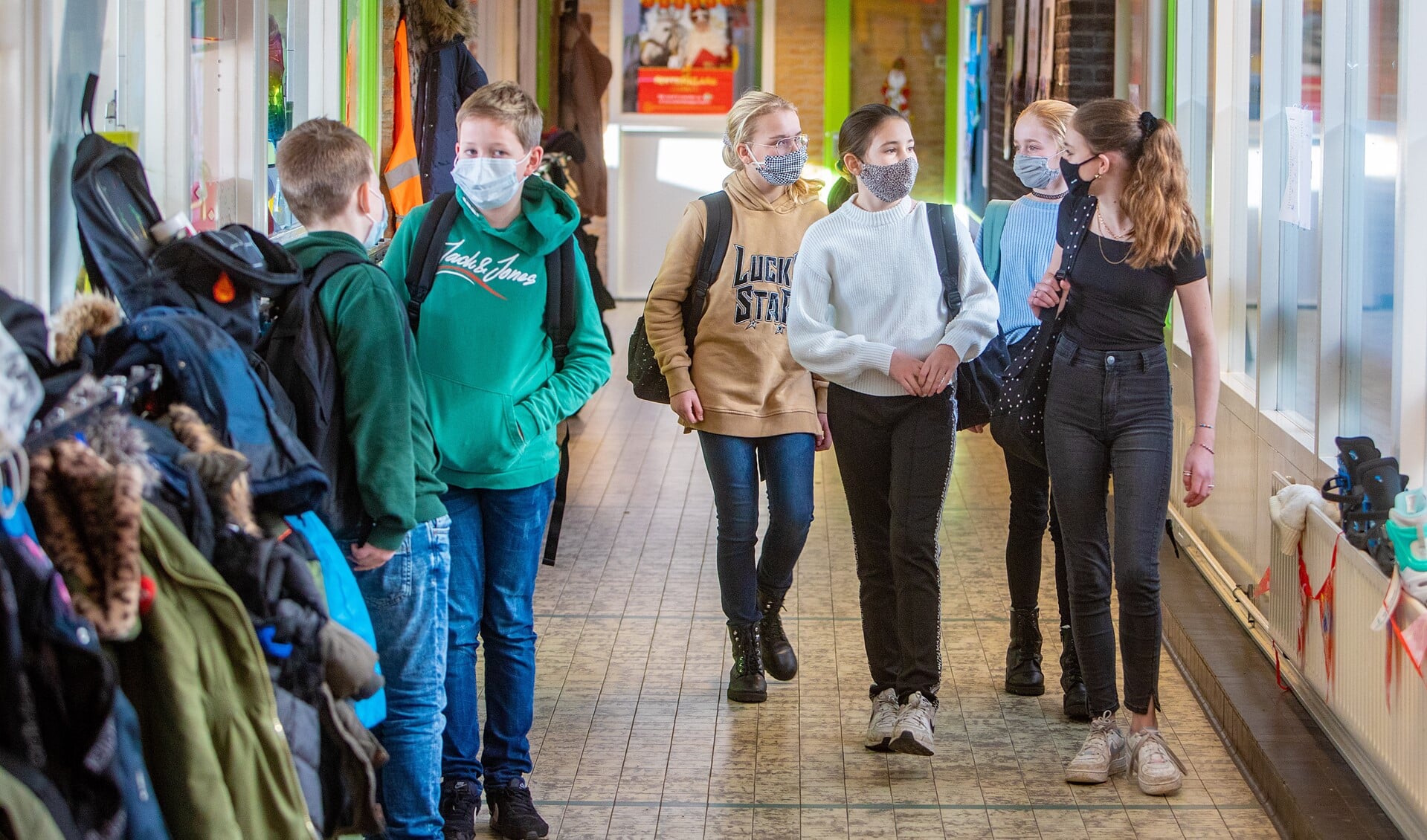 Leerlingen van de bovenbouw van de Rehobothschool dragen in de gang een mondkapje.