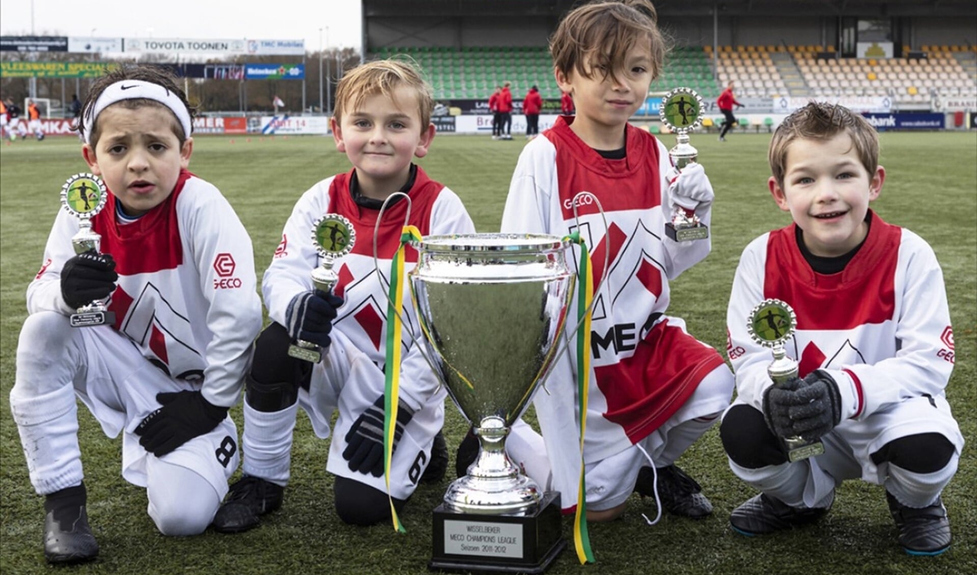 De jonge voetballertjes van 'Ajax' met hun beker en de cup met de grote oren.
