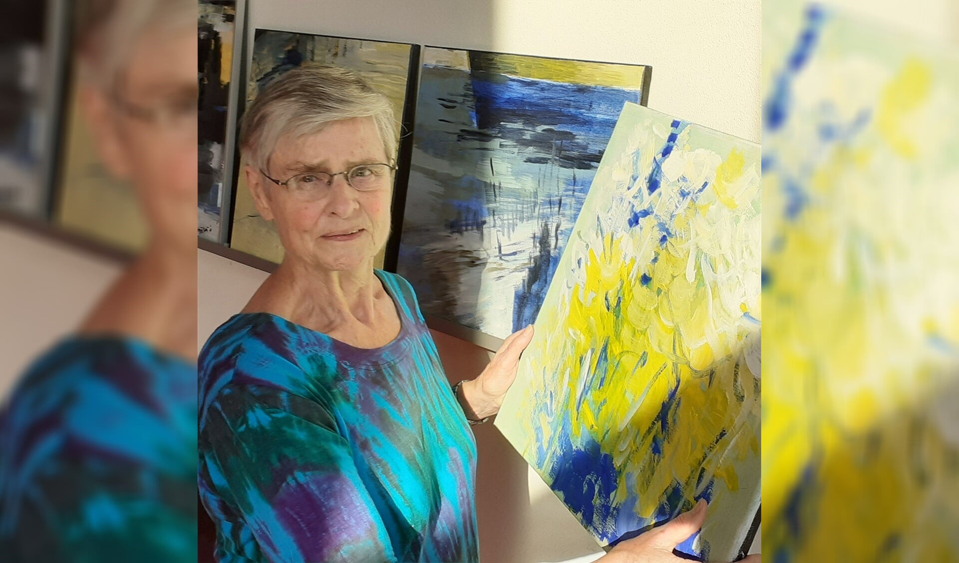 Lenie Bos met een van haar schilderijen.