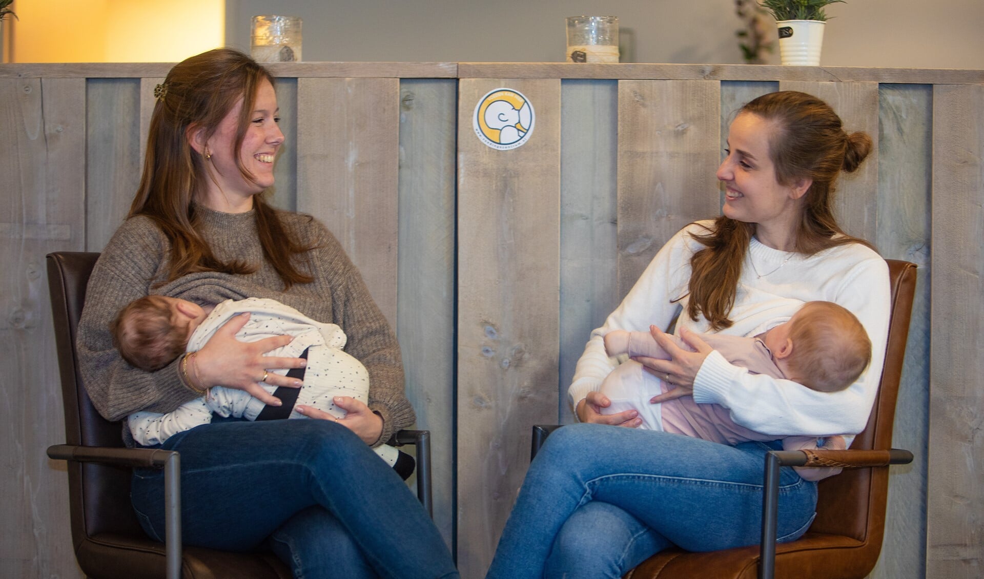 Moeders Feline (l) en Sarina geven borstvoeding bij het logo 'voeden kan hier'.