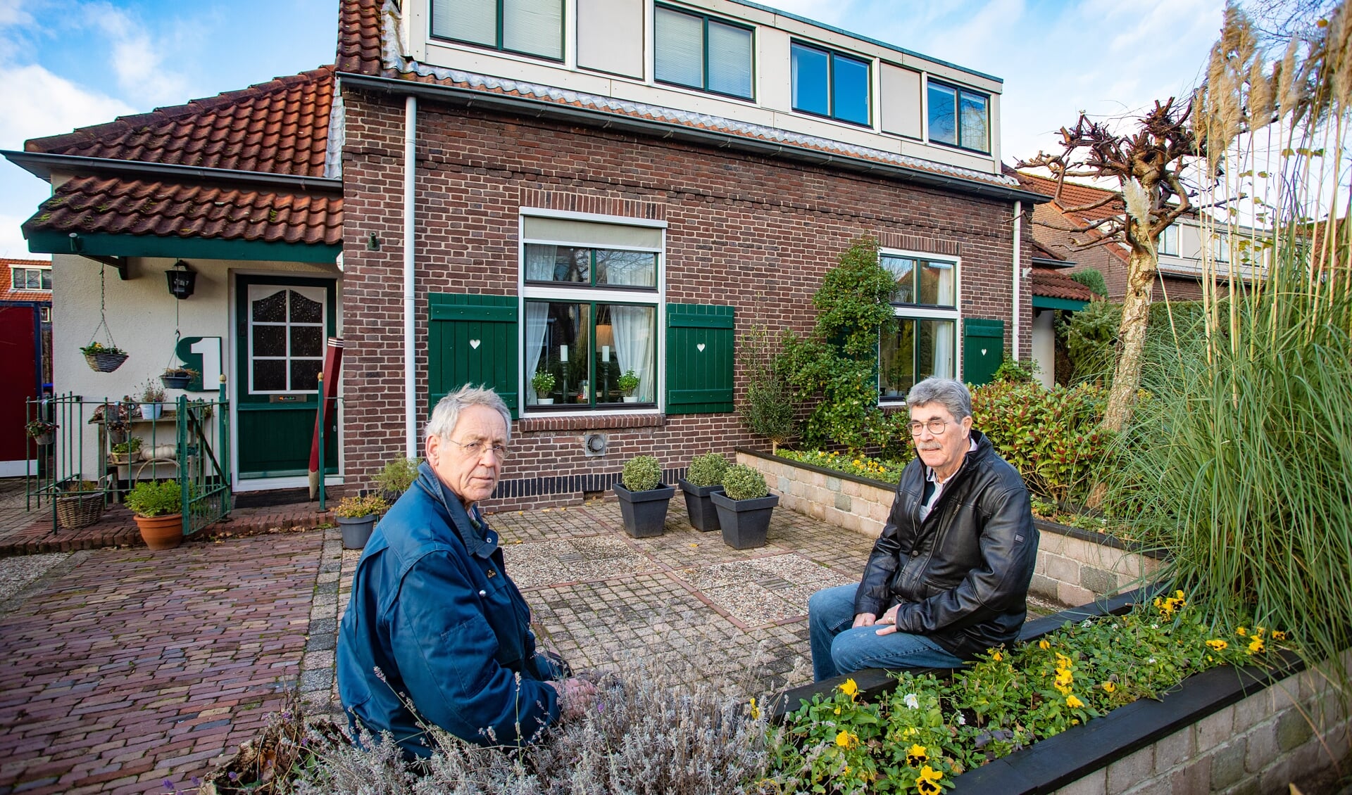 Henk Veenendaal (r) voor zijn huis op de Huibert van Eijkenstraat, met links buurman Gerard van Huissteden.
