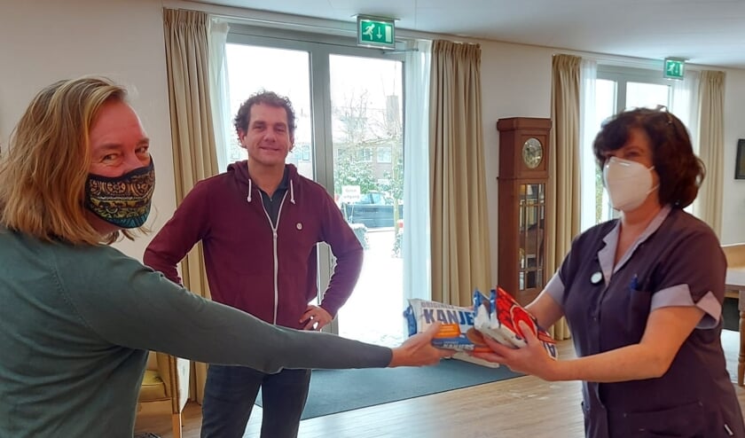 <p>Fractievoorzitter Rolien Bekkema en Joris Thijssen delen de lekkernij uit bij Amaris de Veste.</p>