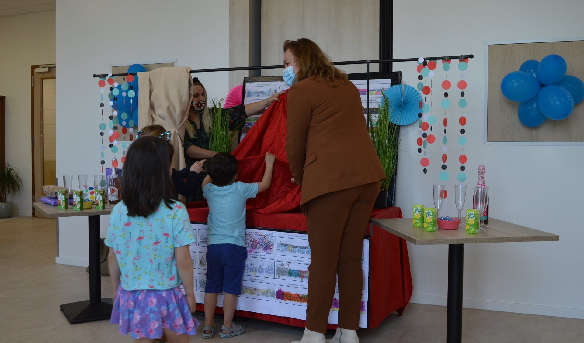 Wethouder Heijstee onthult de tekeningen van de kinderen en opent daarmee officieel de buurtkamer.