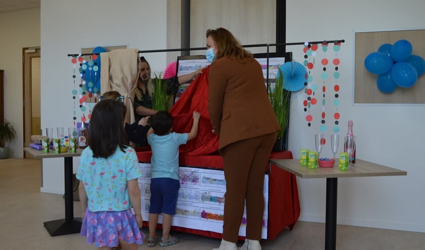 <p>Wethouder Heijstee onthult de tekeningen van de kinderen en opent daarmee officieel de buurtkamer.</p>