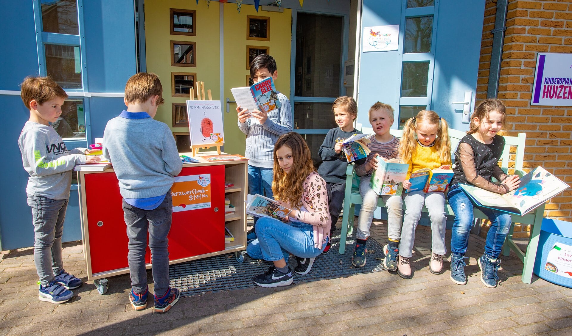 De leerlingen zoeken samen gezellig een boek uit bij het KinderzwerfboekStation. 