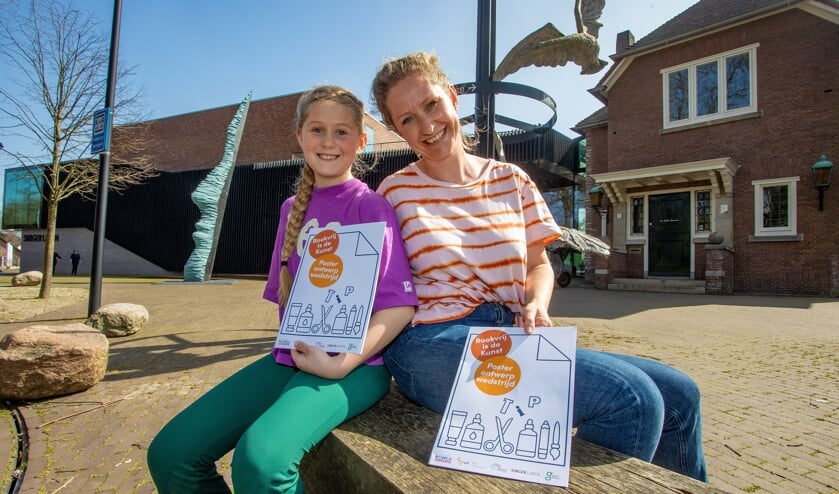 <p>Dochter Jasmijn mocht van moeder Dineke Soer het werkboekje 'Rookvrij is de Kunst' alvast uitproberen.</p>