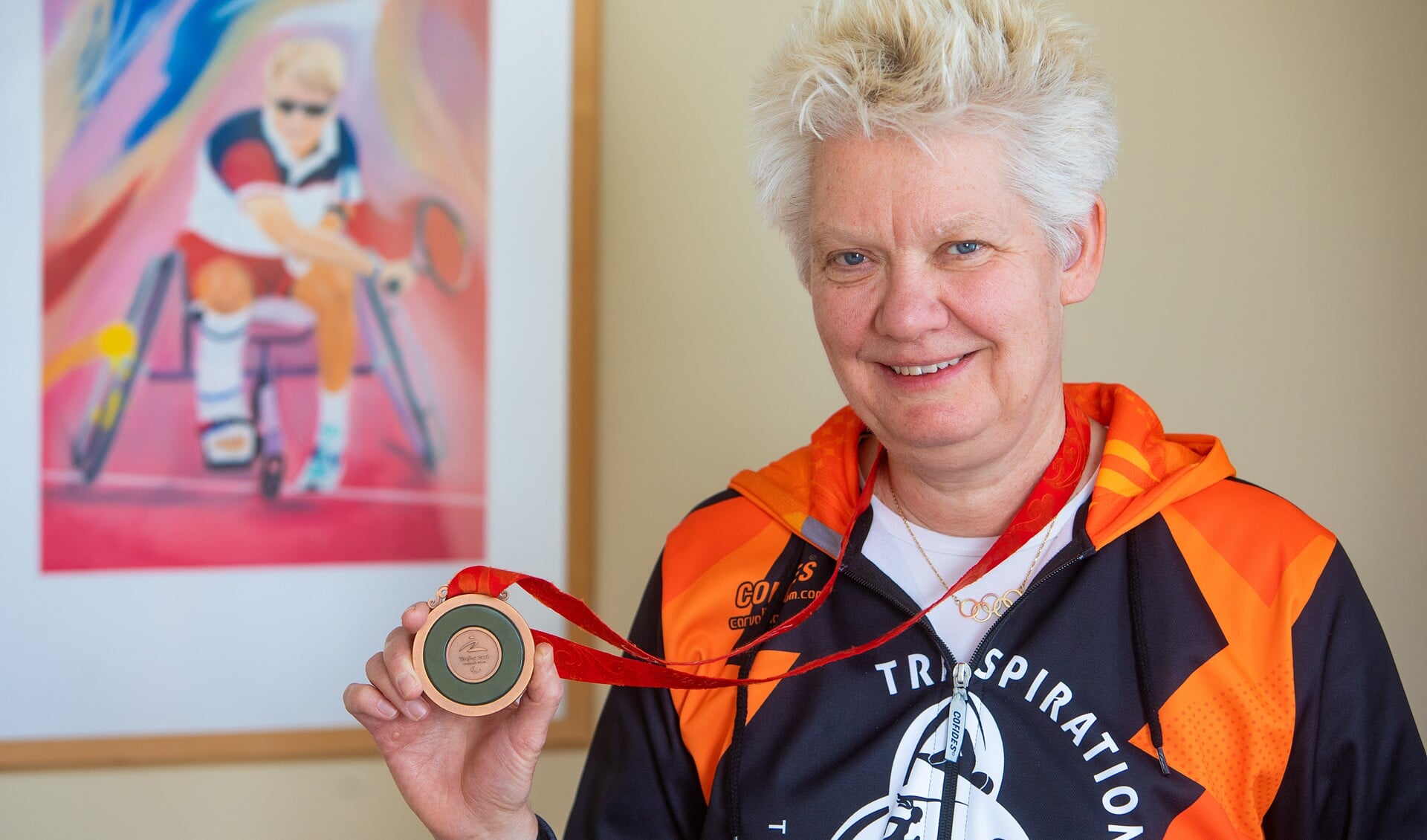 Djoke van Marum toont haar bronzen medaille van de Paralympische Spelen, die ze ook meeneemt naar scholen als ze daar op bezoek gaat.