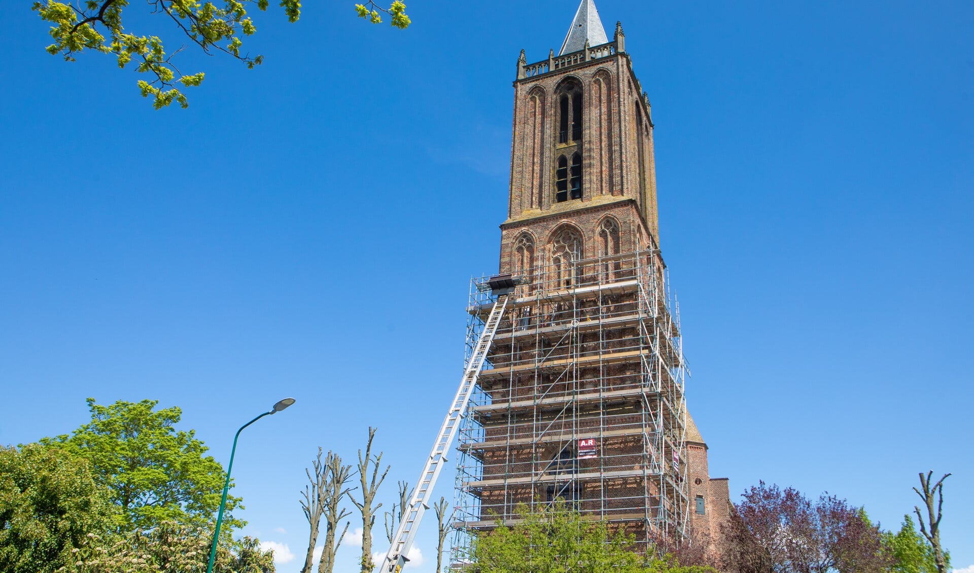 De toren van de Nicolaaskerk staat in de steigers voor onderhoud.