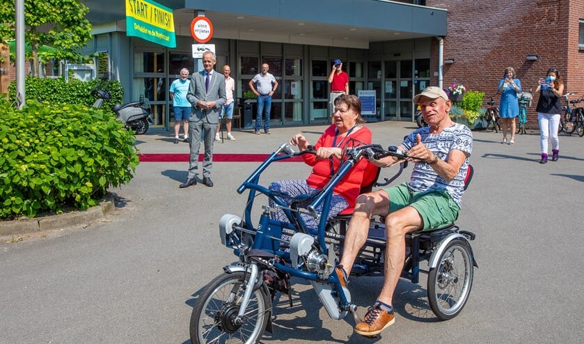 <p>Burgemeester Niek Meijer kijkt toe hoe de nieuwe duofiets in gebruik wordt genomen.</p>