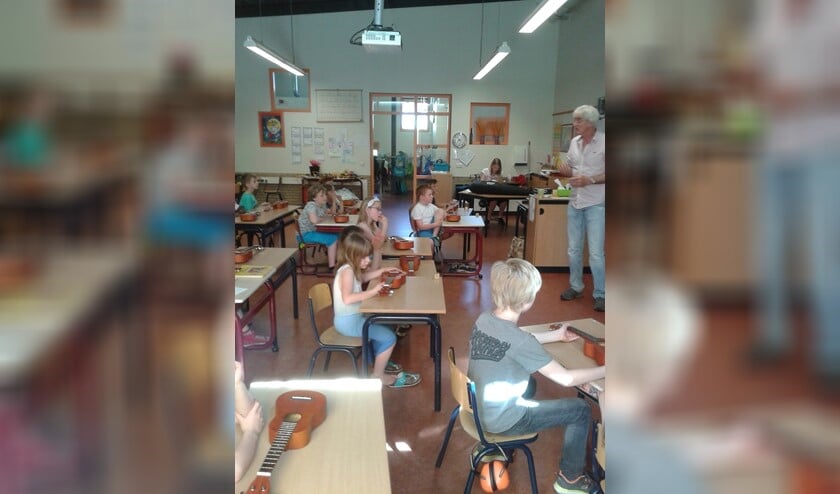 Tijdens een ukelele-workshop van muziekdocent Eddy van Bennekom (r) op een school ergens in Noord-Holland.