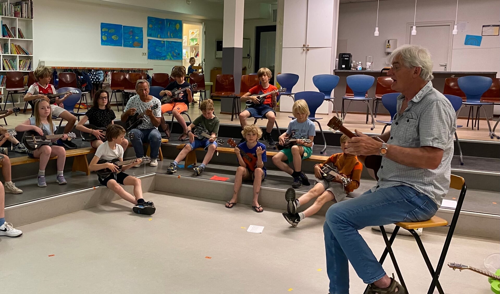Muziekdocent Eddy van Bennekom leert de kinderen van Groep 8 van de Gooilandschool de fijne kneepjes van het ukelele spelen.