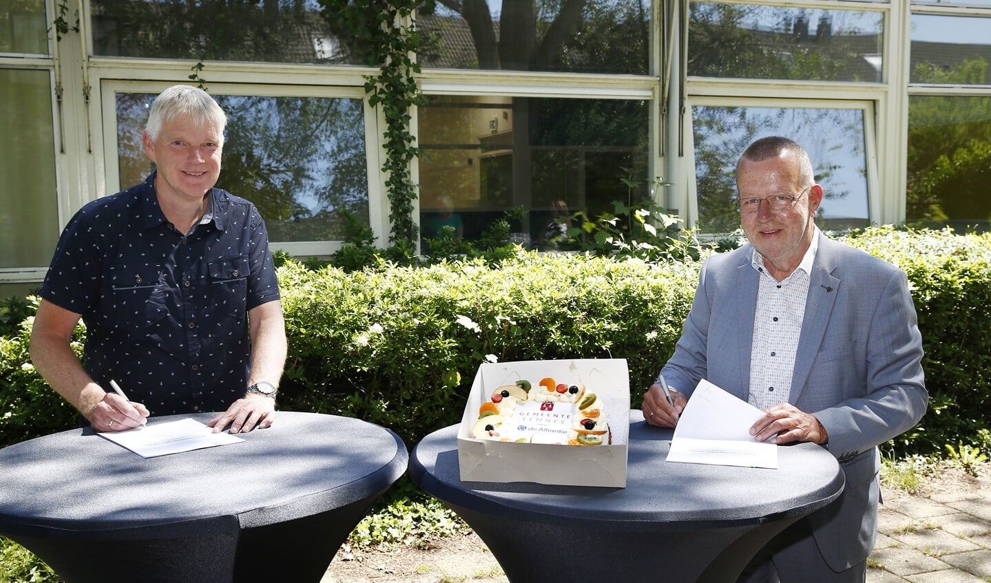 Theo Reijn en Jan van Barneveld ondertekenen koopovereenkomst op de plek van de voormalige basisschool De Hink Stap Sprong in Eemnes. 