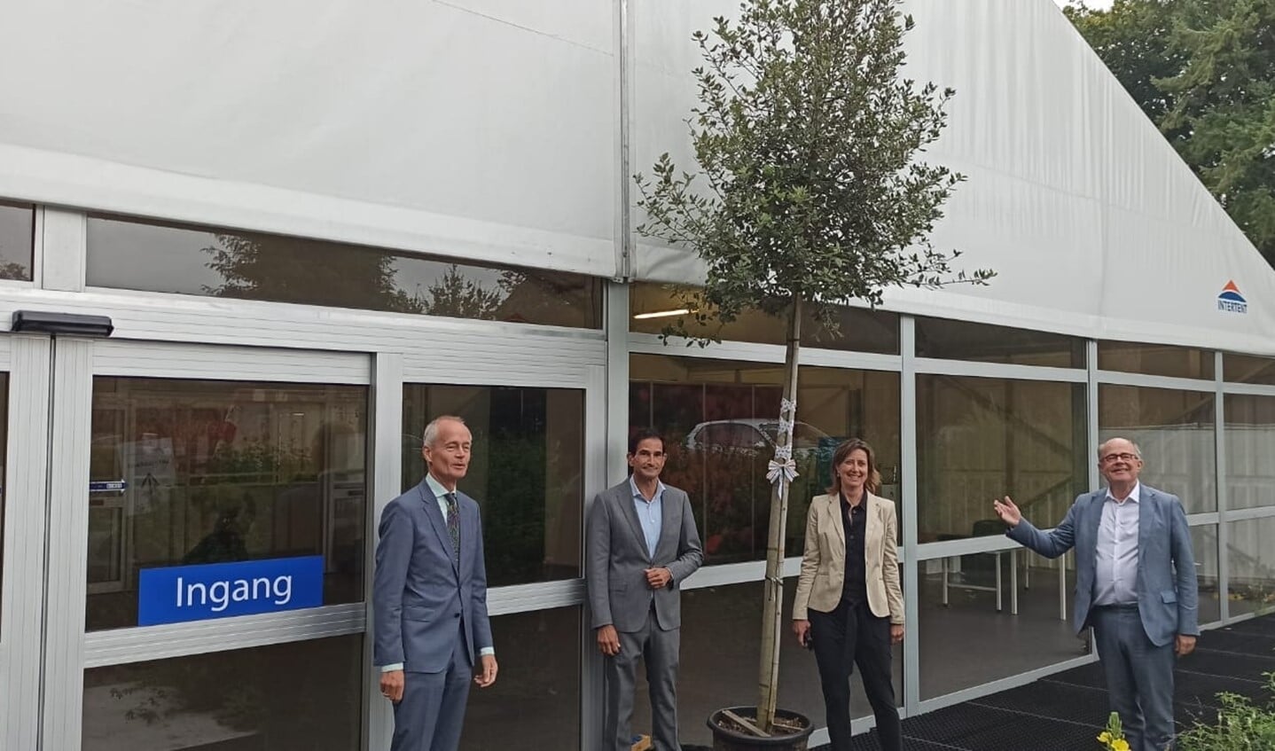 René Stumpel, Annelies Versteegden, burgemeester Niek Meijer en wethouder Maarten Hoelsscher naast de boom die Visio als dank van de GGD ontving.