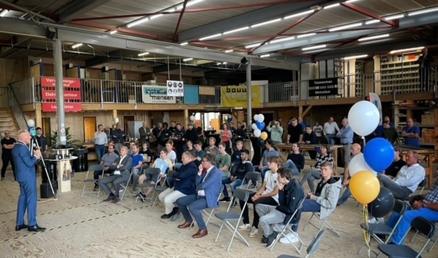 Burgemeester Han ter Heegde met leerlingen en leermeesters in het nieuwe pand van Bouw- en Installatiemensen Gooi & Vechtstreek.