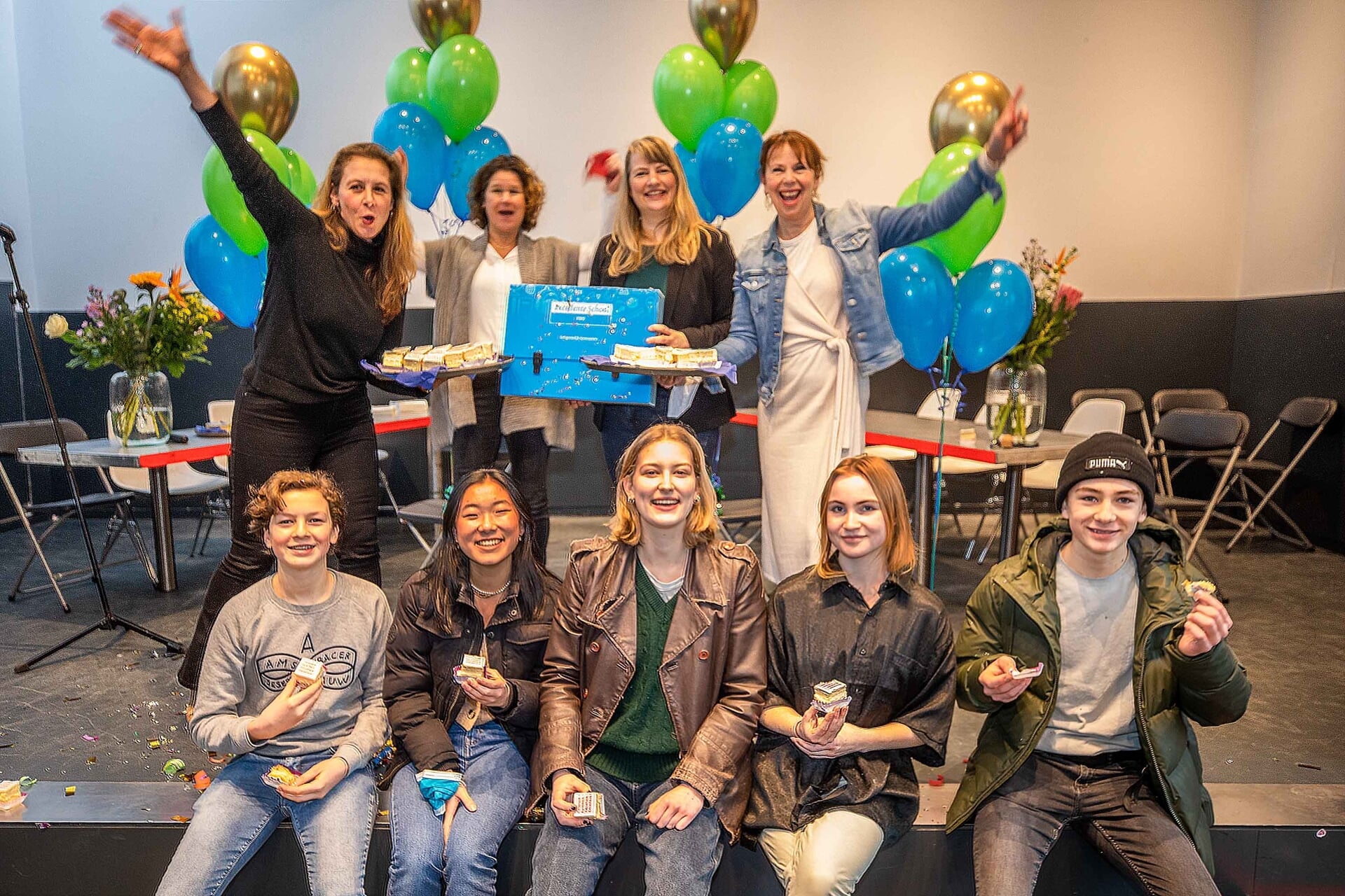 Leerlingen en docenten vieren predicaat 'Excellente School' met taart en ballonnen.