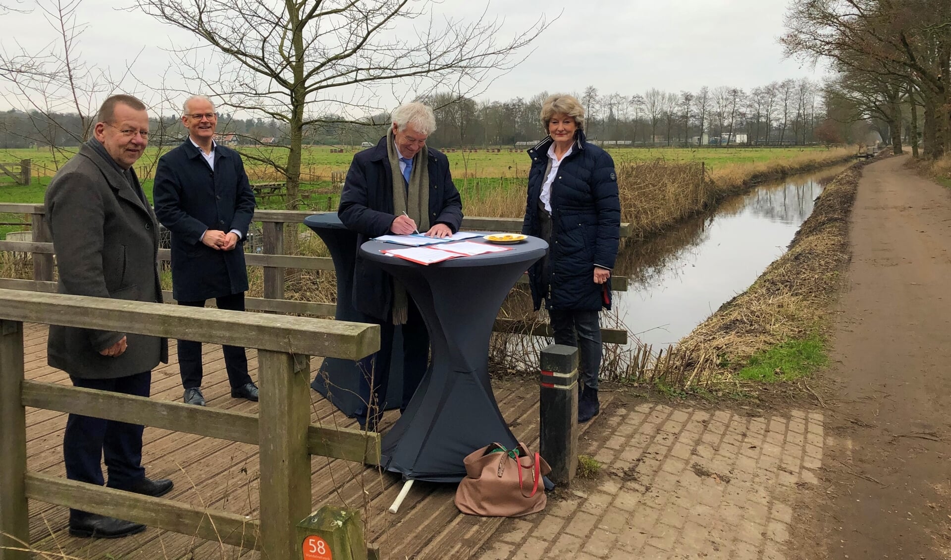 Theo Reijn, Peter Smit, Peter Calis en Maria Klingenberg-Klinkhamer ondertekenen de overeenkomst bovenop de Gooiergracht.