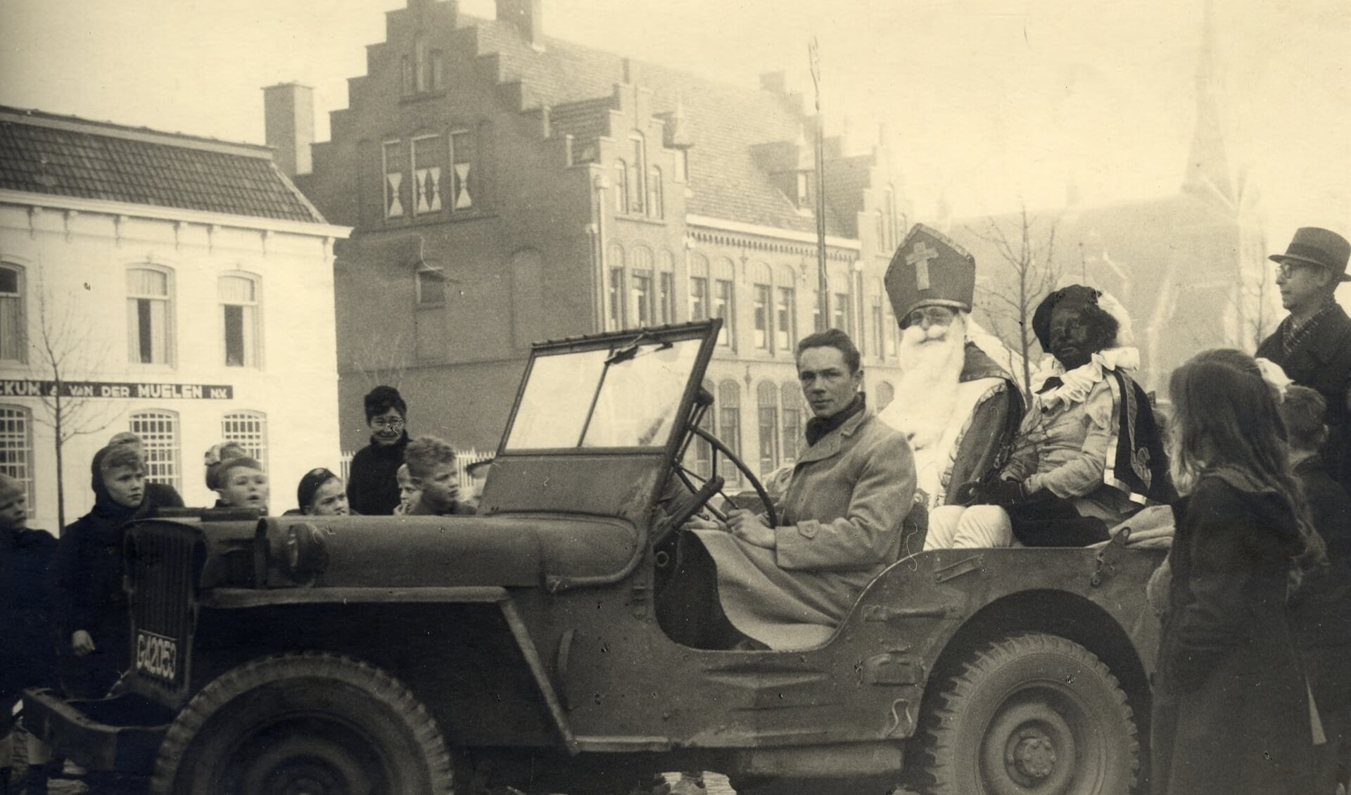 Sinterklaas en Zwarte Piet in een Jeep op de Pleinbrug. 