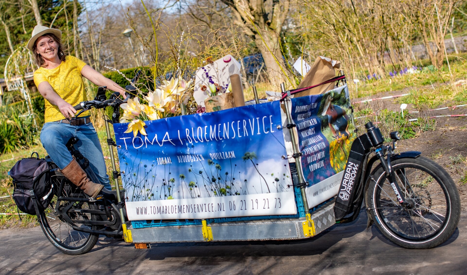 Toma Smit op haar bakfiets waarmee ze met haar bloemen heel Hilversum af fietst.
