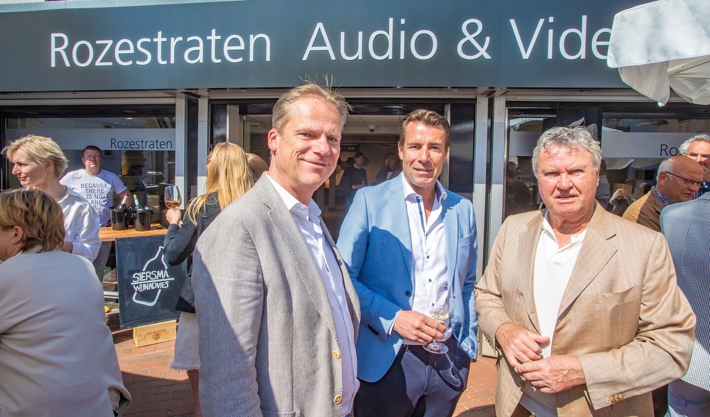 Guus Hiddink (r) met de broers Rozestraten voor hun winkel.
