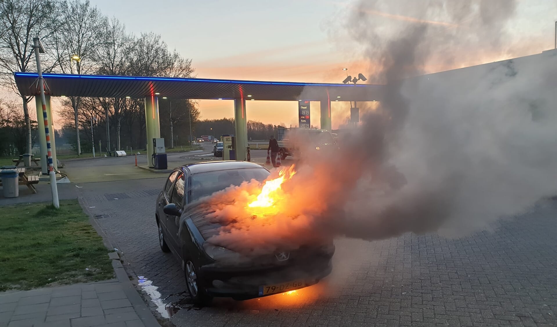 De auto in brand bij het tankstation.