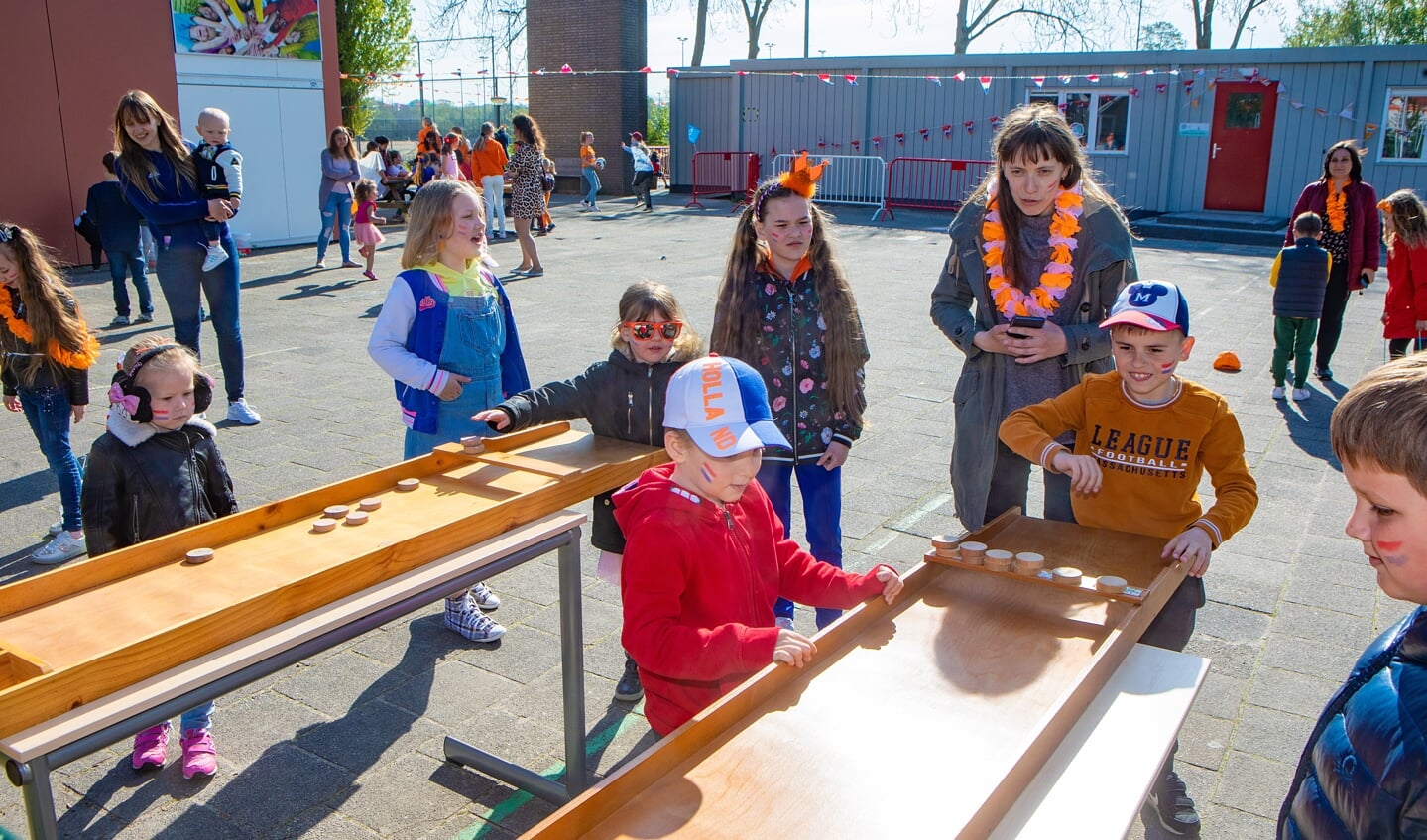 Nederlandse en Oekraïense kinderen sjoelen samen tijdens de Koningsspelen op de Tweemaster in Naarden.  