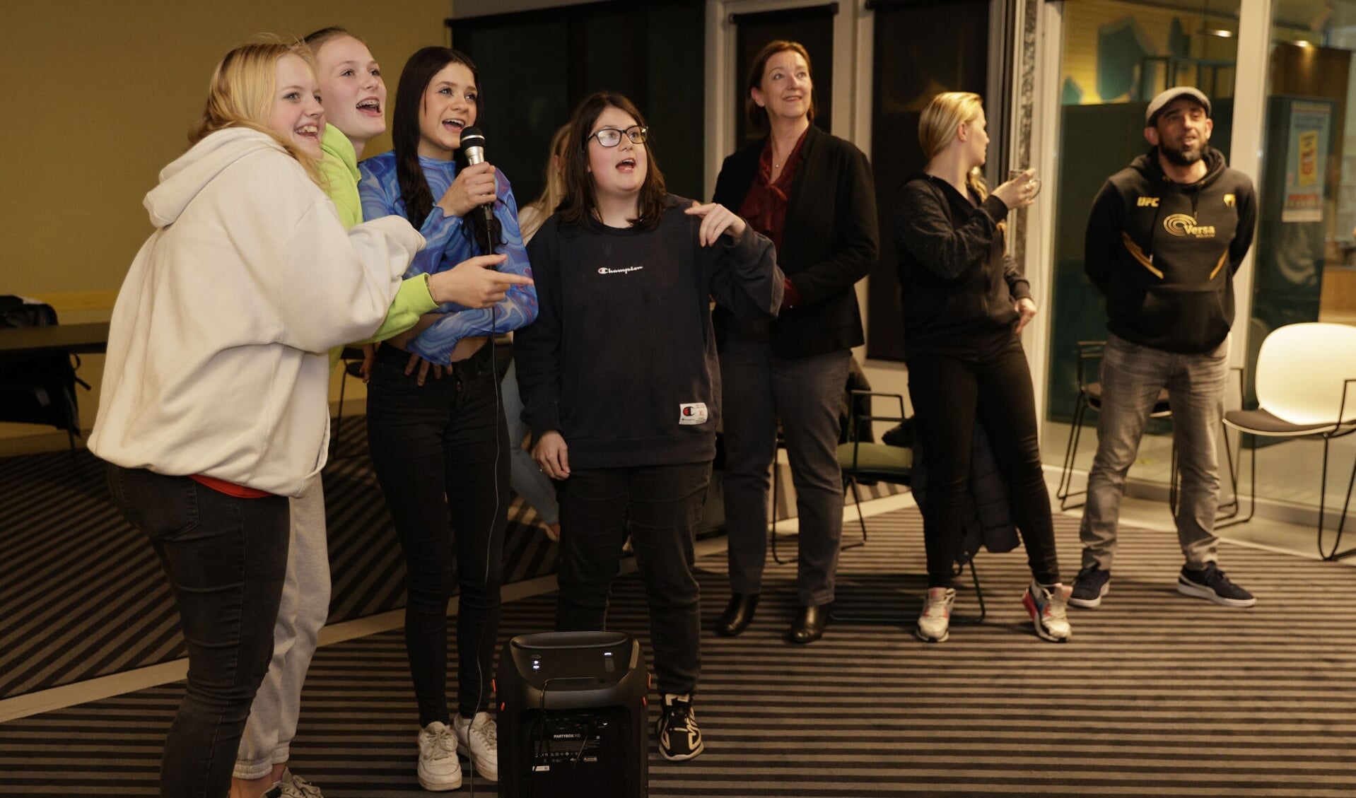 Wethouder Wilma de Boer - Lijsma kijkt toe hoe er gezongen wordt op de meidenavond.