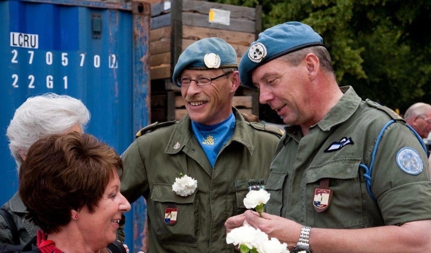 Fred Janssen (r) deelt witte anjers uit.