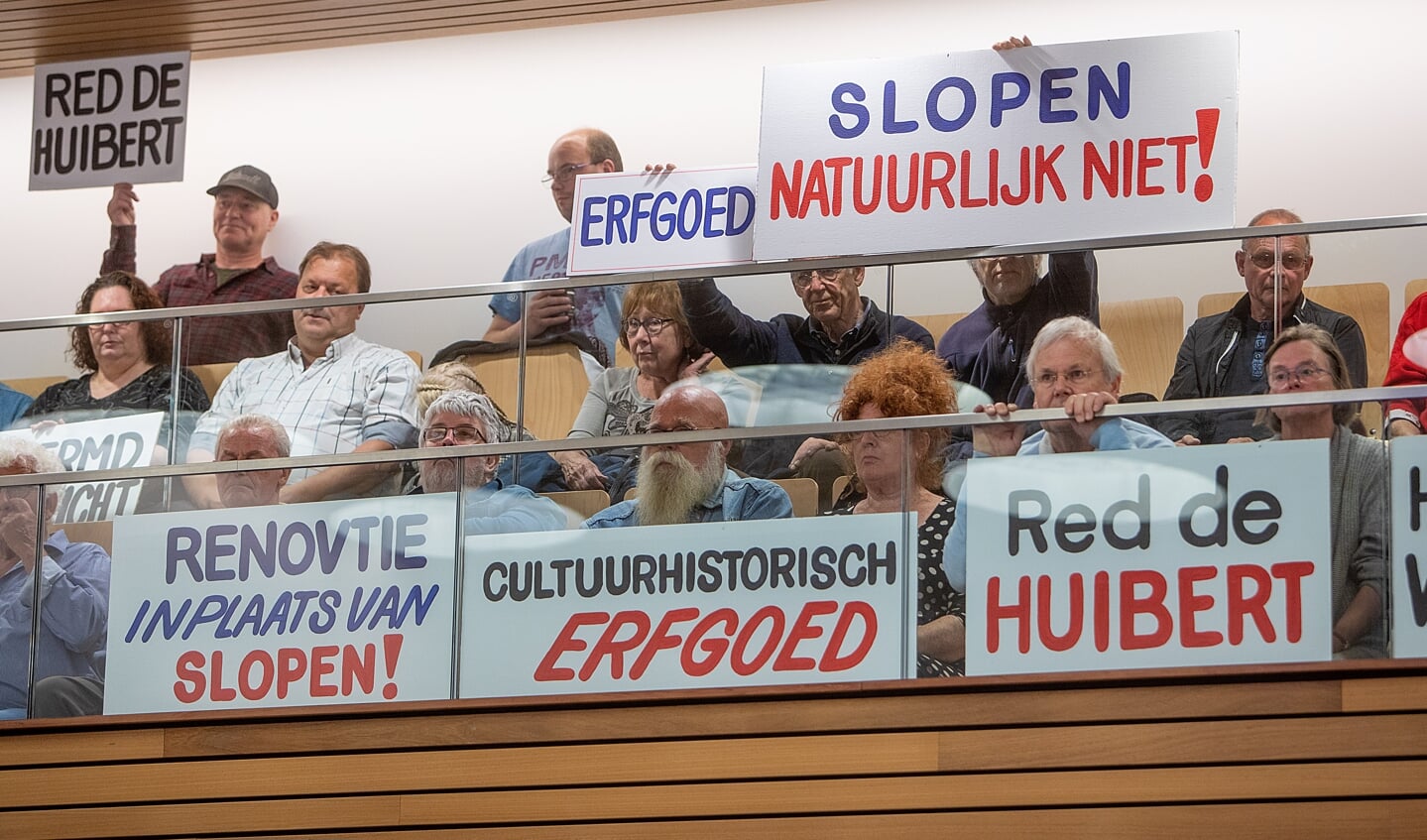 Tegenstanders van de sloop houden spandoeken vast.