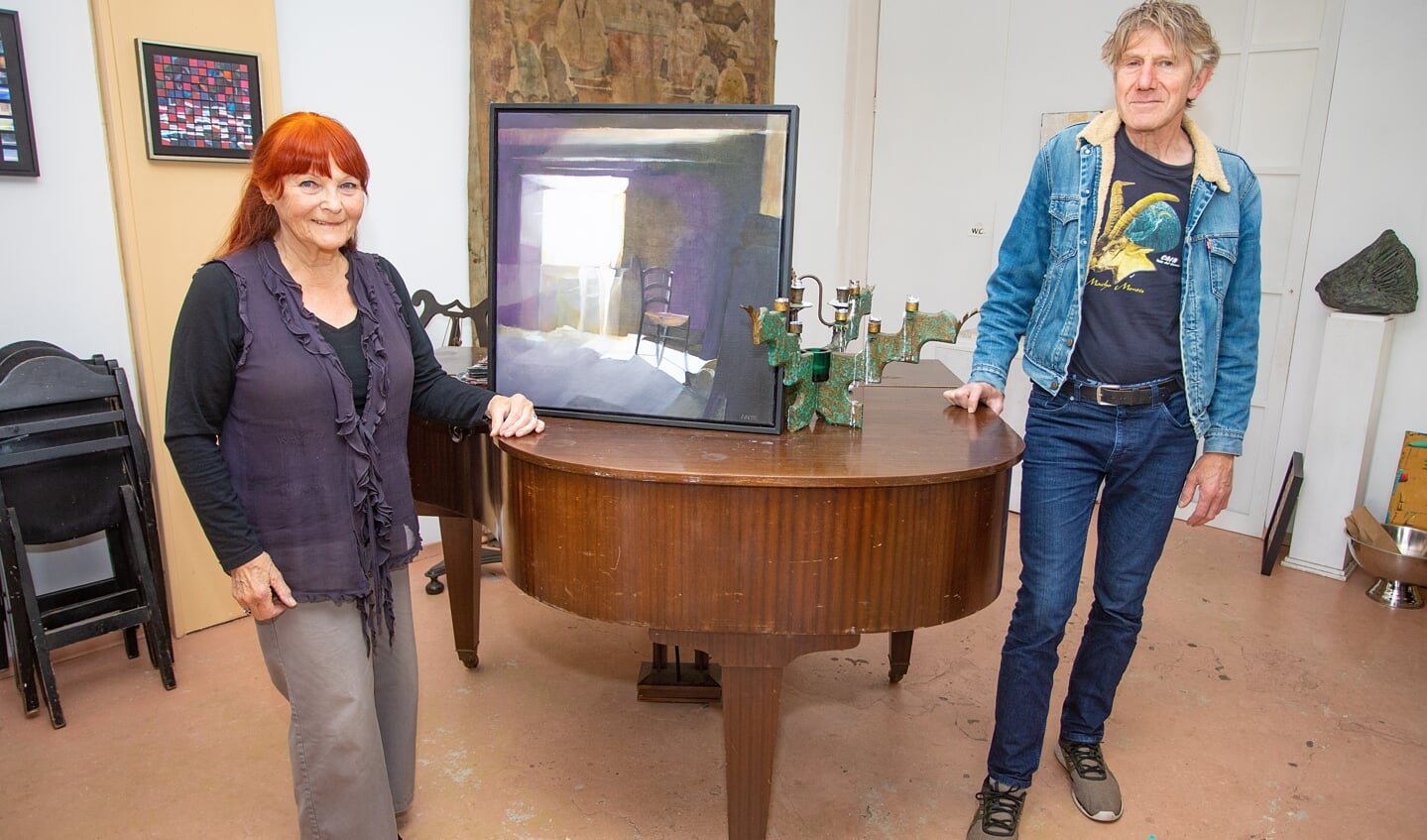 Kunstschilder Loes Koopman, met een van haar doeken en rechts daarvan kunstenaar Ernest Laeven.