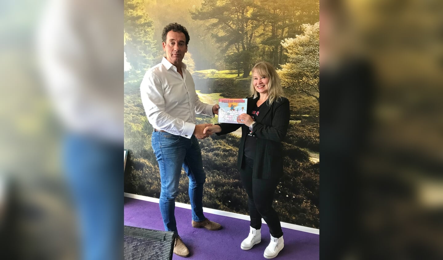 Wethouder Roland Boom krijgt het eerste exemplaar uit handen van Femke Krone.
