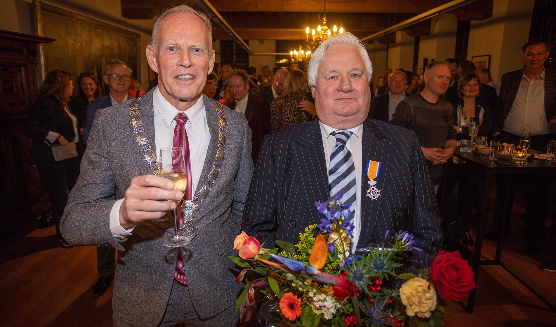 Joop van Dort is koninklijk onderscheiden. De burgemeester mocht hem de versierselen opspelden.