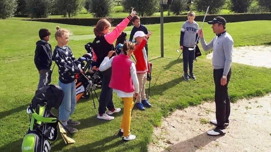 Jan Zwemmer geeft golfles aan kinderen.
