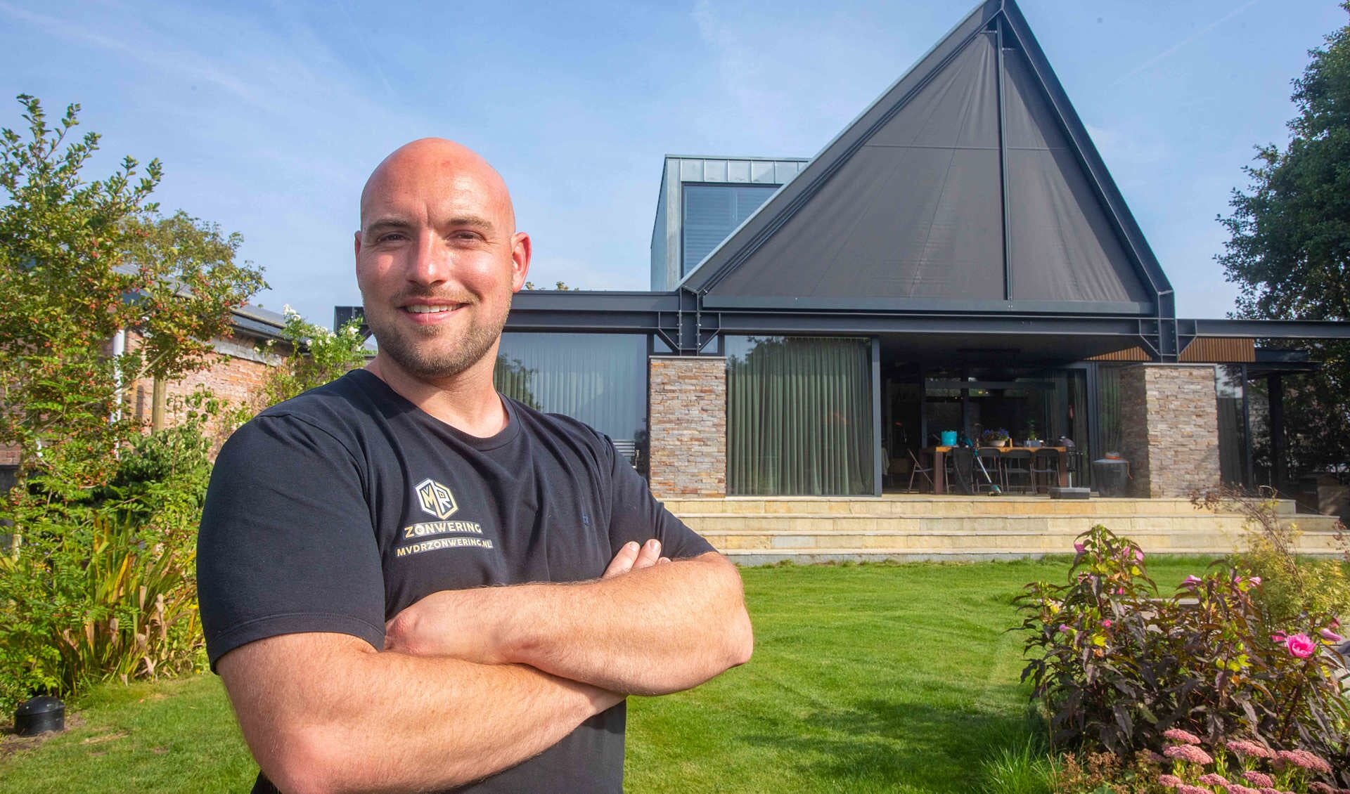Mitchell bij een van zijn projecten in Ankeveen, waarbij hij zonwering aan het maken is voor een driehoekig raam (een van zijn specialiteiten).