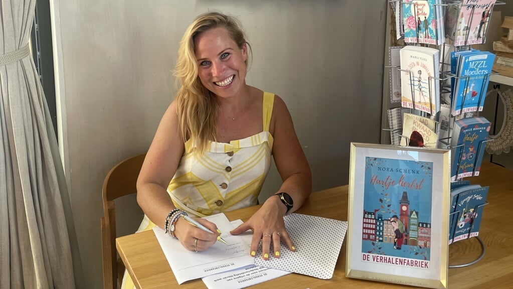 Nora Schenk tekent haar boekcontract bij Uitgeverij De Verhalenfabriek.