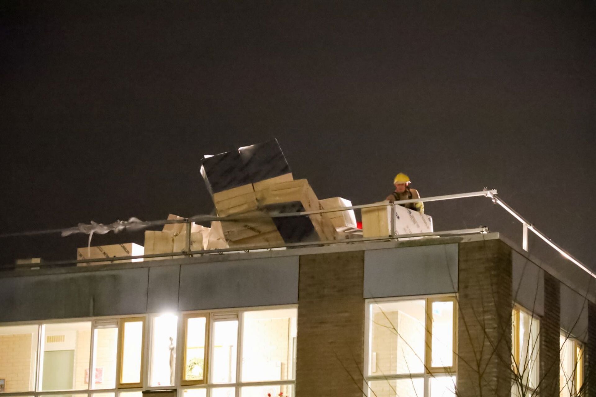 De brandweer moest tegen middernacht wel diverse materialen op een dak aan de H.A. Lorentzweg in Bussum veilig stellen.