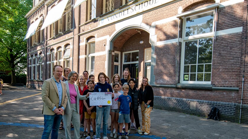 Leerlingen van de Bussumse Vondelschool overhandigen de cheque aan stichting Maatjesproject Gooi en Vechtstreek