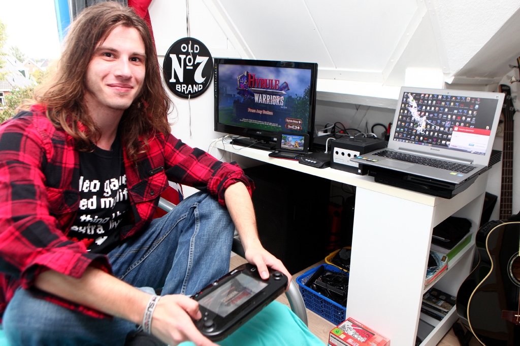 Frank Daniel op zijn kamer met verschillende apparaten om op te kunnen gamen.