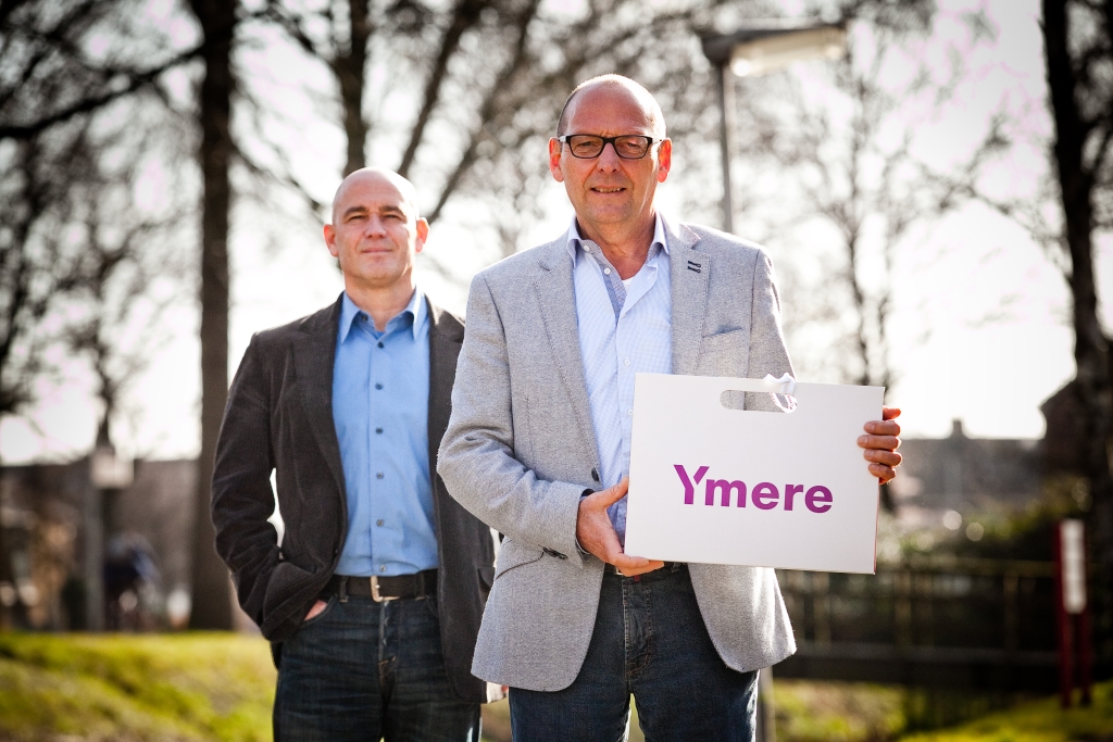 De Woningbouw gaat over in Ymere. Jan Turenhout (links) maakt plaats voor Kees Kunst. 'Zonder fusie hadden we de deuren moeten sluiten.'