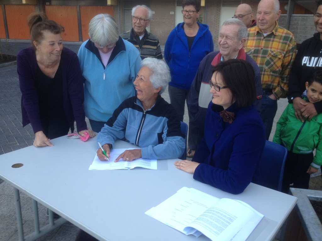 Bewoners en wethouder Maïta van der Mark ondertekenen overeenkomst.