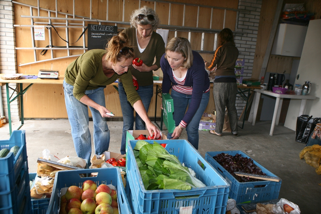 De vrijwilligers verdelen de verse groenten in porties.